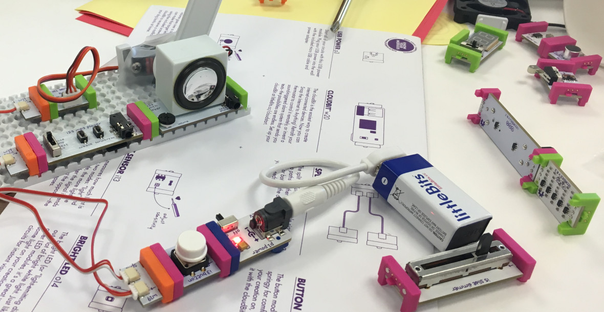 littleBits components connected via wires and a batter, sitting on a print instruction set