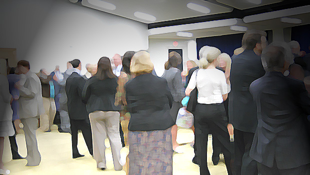 A photoshopped image of people talking in a brightly lit auditorium