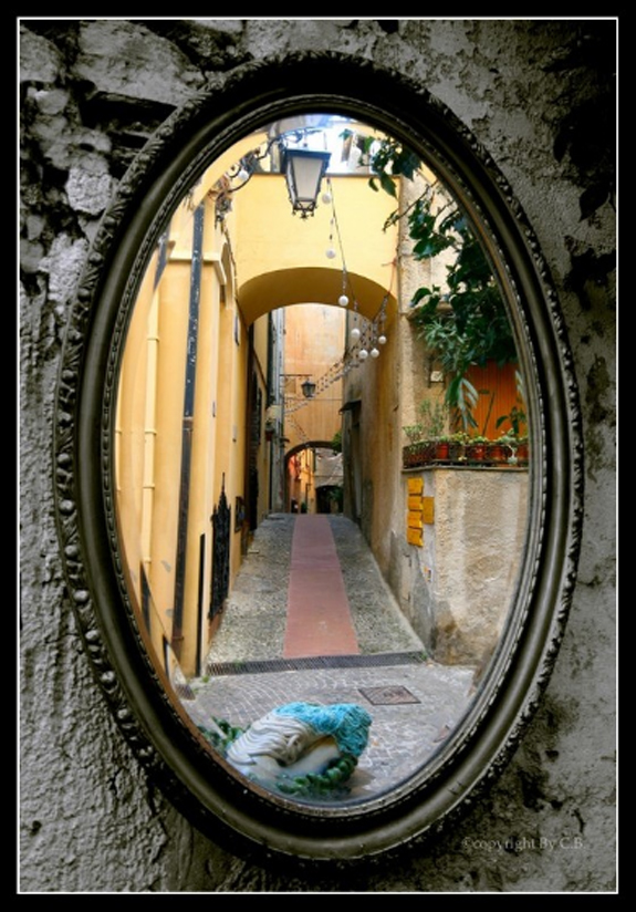 antique mirror reflection of empty alley with lanterns