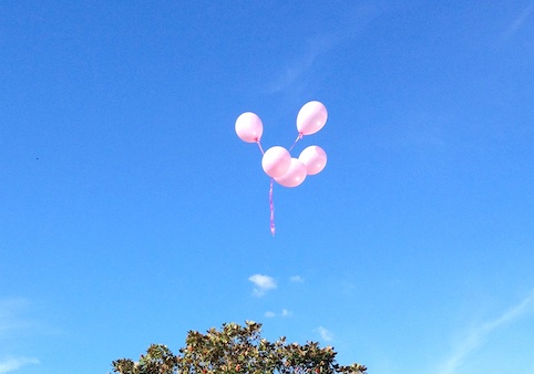 five pink balloons being let go