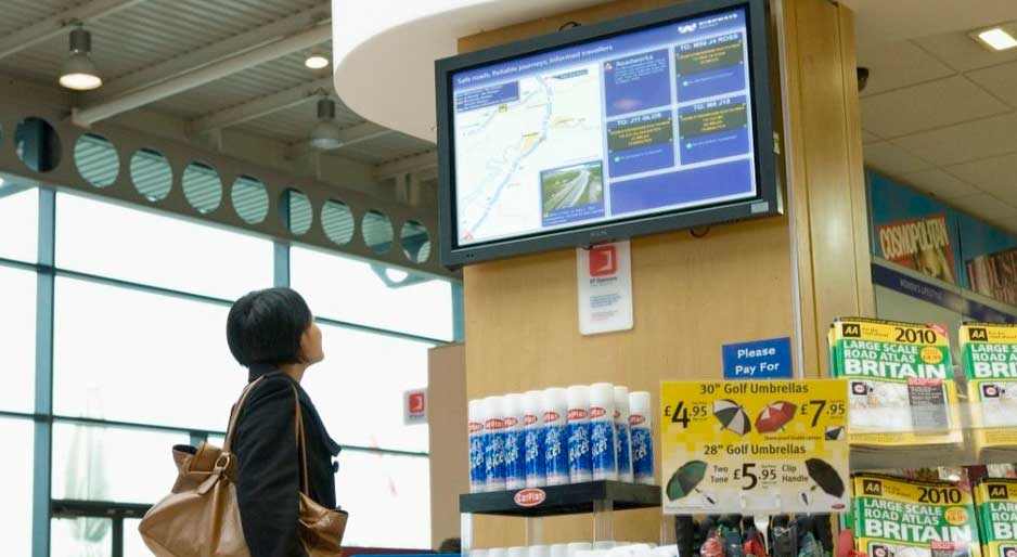 woman staring at television screen in store