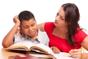 Stock photo of a distressed boy being comforted by a teacher