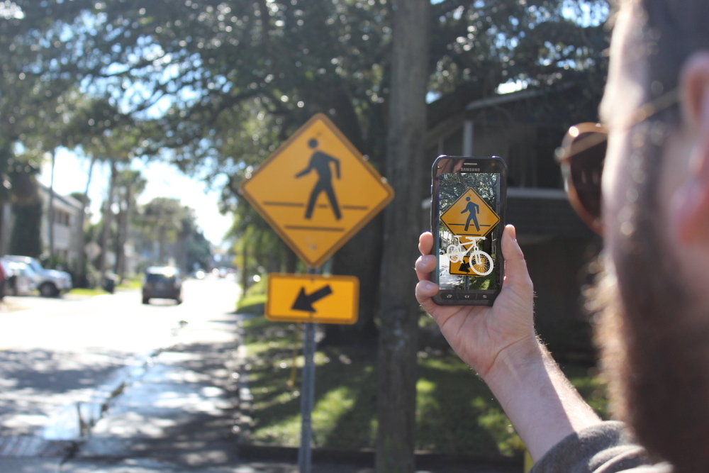 Augmented reality image of ghost bike superimposed over pedestrian crossing sign